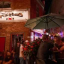 Heart and crown patio, friends drinking under green umbrella